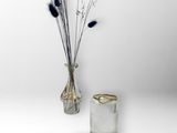 un vase avec des fleurs et une paire de bagues sur la table