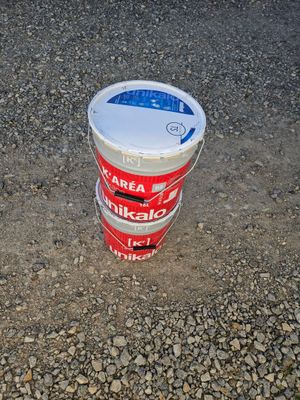 a bucket sitting on the ground next to a trash can