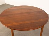 a round table with a wooden top on a concrete floor
