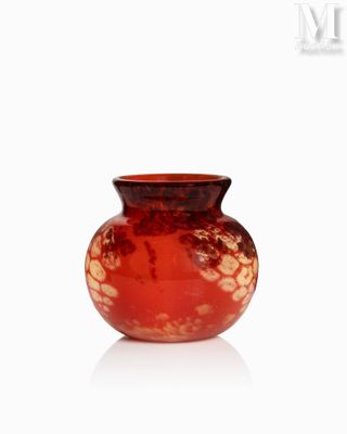 un vase rouge posé sur une surface blanche