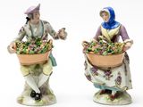 two figurines of women with baskets of flowers on their heads