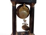 a black and gold clock with a bell on top of it