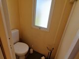 une petite salle de bains avec des toilettes et une fenêtre