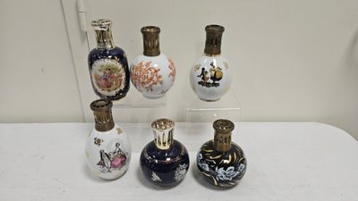 five bottles of perfume sitting on a white table