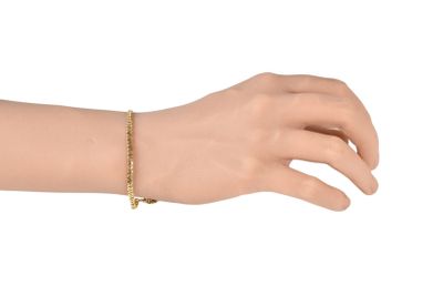 gold plated bracelet with a cross charm on a mannequin hand