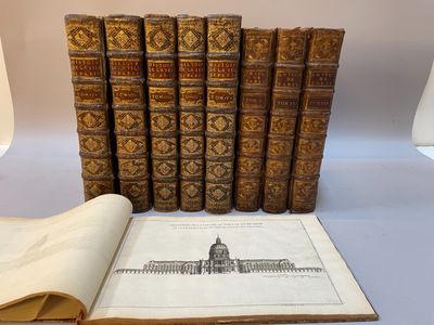 plusieurs vieux livres posés sur une table à côté d'une lampe