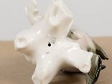 porcelain figurine of a bird on a branch with a flower