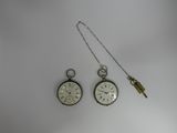 two clocks that are sitting on a white surface