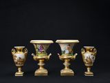 trois vases dorés posés les uns à côté des autres sur une table noire