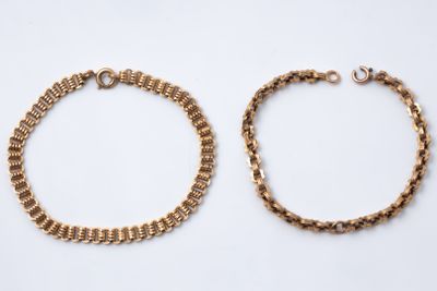 a pair of gold bracelets on a white background