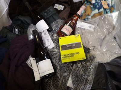a pile of clothes and bottles of wine on the floor