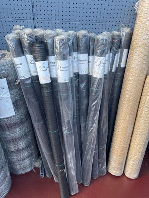 many rolls of fabric on a shelf in a store