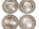 quatre assiettes plaquées argent sur fond blanc