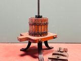 une photo d'une machine à fabriquer des blocs de bois posée sur un fond rose
