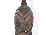 une image représentant une statue en bois surmontée d'une plume