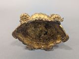 an image of a gold colored object on a white surface