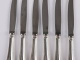 a set of five silverplated knives with a silver handle