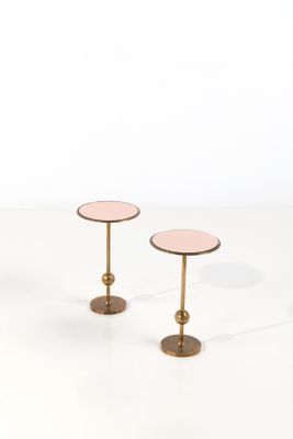 a pair of pink side tables with gold bases on a white surface