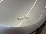 a close up of a silver car with a sticker on it