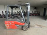 a forklift in a warehouse with a lot of motorcycles in the background