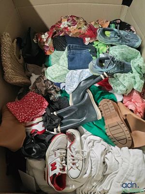 une boîte remplie de vêtements et de chaussures qui s'y trouvent