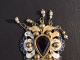 a close up of a necklace with pearls and a heart shaped pendant