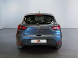 the back of a blue car parked in a room with a white wall