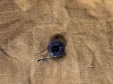 a small piece of fabric with a blue button on it
