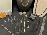 several necklaces, bracelets, and other jewelry are displayed on a table