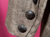 a close up of a suit with buttons on a pink background