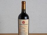 une bouteille de vin rouge posée sur une table en bois