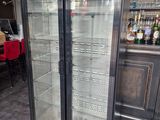 a glass door refrigerator in the middle of a room