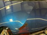 a close up of a blue car with a guitar on it
