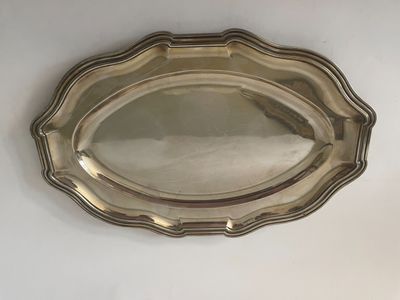 un plateau ovale en argent avec un motif décoratif sur le bord