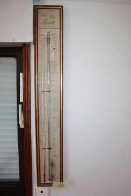 a tall thermometer on the wall in the corner of the room
