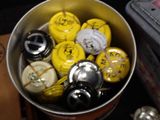 a lot of yellow and black buttons in a metal container