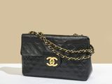 a black chanel bag with a gold chain hanging from it