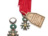 une photo représentant une paire de boucles d'oreilles et un ruban muni d'une étiquette