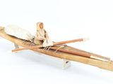 un petit bateau en bois avec deux personnes à bord