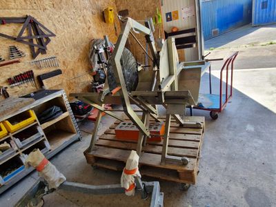 Plusieurs morceaux de bois sont empilés sur des palettes dans un garage
