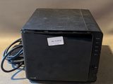 une petite boîte noire posée sur une surface blanche