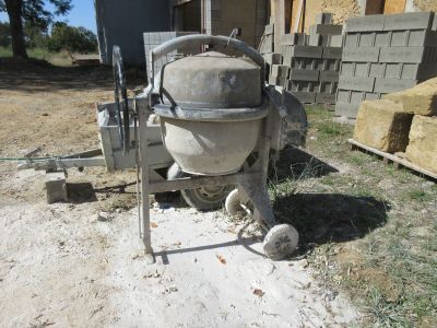 une bétonnière qui est posée par terre