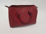 a red handbag sitting on top of a white table