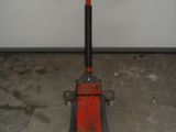 une photo d'un cric de garage rouge et noir dans un garage