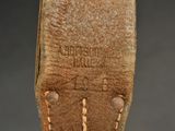 brown leather belt with stitching on the side of the belt