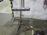 un tuyau métallique posé sur un trépied dans un garage