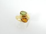 un gros plan d'une bague en or sertie de deux pierres de couleurs différentes