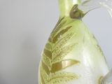 a glass vase with a green and gold design on it