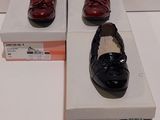 une paire de chaussures rouges et noires posée sur une boîte blanche