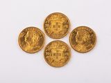 four gold coins are arranged on a white surface